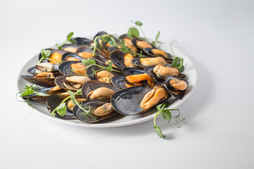 Lots of mussels with green on the plate