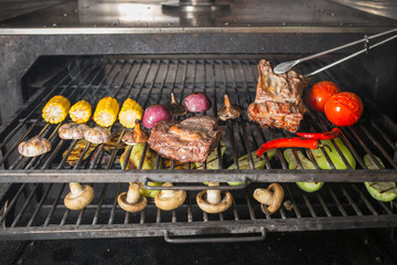 Vegetables and meat on the grill on hot coals with smoke