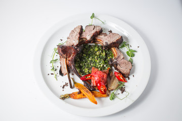 Baked lamb with vegetables on white plate
