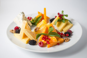 Lots of cheese with honey, grape, nuts, berries and mint