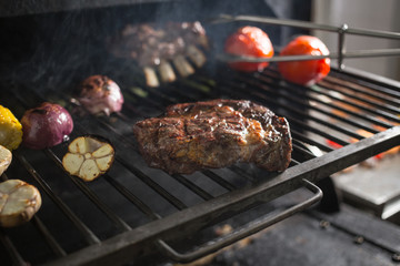 Vegetables and meat on the grill on hot coals with smoke