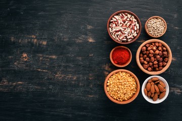 bowls of various superfoods. On a black wooden background. Top view. Free copy space.
