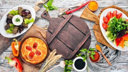 Assortment of dishes of Georgian and European cuisine. On the old wooden background. Free space for text. Top view.