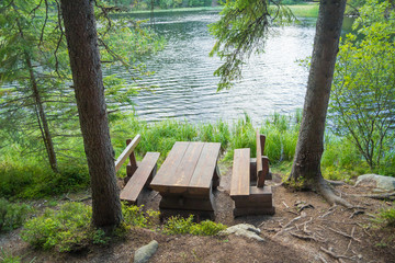 picnic table seating in forest near lake