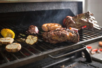 Vegetables and meat on the grill on hot coals with smoke