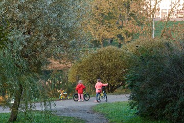 two little girls on bicycles in the city Park