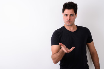 Young handsome Persian man against white background 