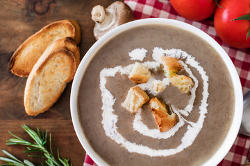 Mushroom cream soup with herbs and spices. Homemade, country styled chanterelle Cream-soup on wooden table.