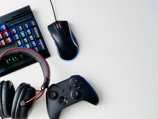 gamer workspace concept, top view a gaming gear, mouse, keyboard, joystick, headset and mouse pad on white table background