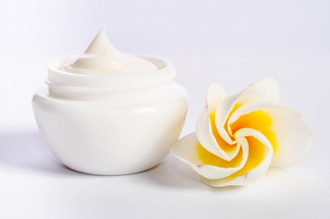 Beautiful flower with natural skincare cream on white background