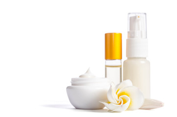 Beautiful flowers and bottles with natural skincare cream isolated on white background
