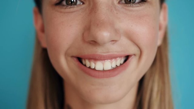 Close up of a teen cute girl face. Portrait shot. Close-up face of a beautiful blonde with dark eyes and beautiful smiling