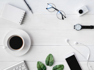 top view of office desk workspace with coffee cup, notebook, plastic plant, smartphone and keyboard on white background, graphic designer, Creative Designer concept.