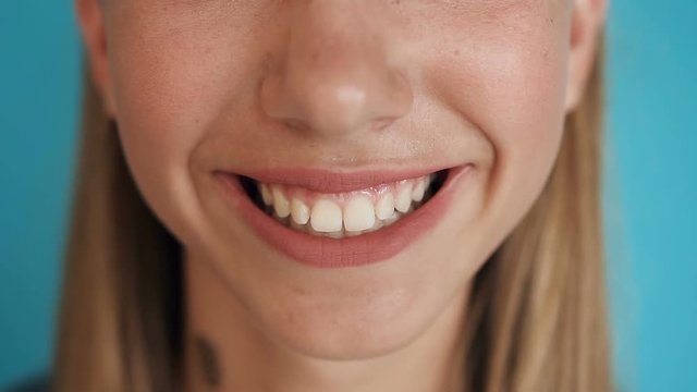 Close up of female smile with white healthy teeth, fashion model clean sexy smile with perfect teeth. Extreme close up of girl mouth smiling