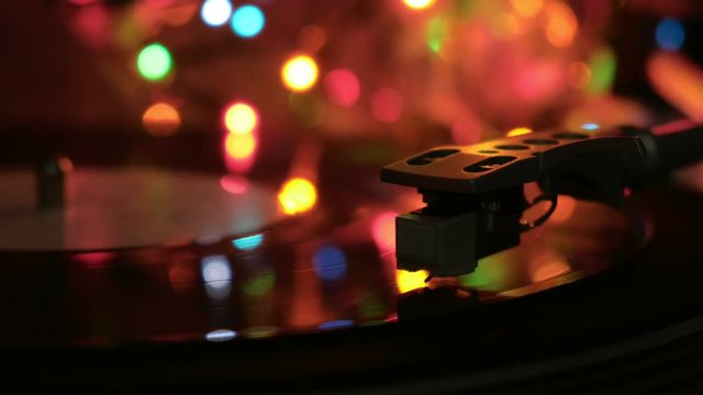 Vinyl disc is playing on retro record player. Needle run on the disc. Macro.