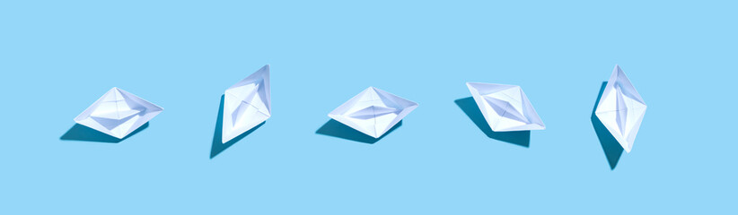 Collection of paper boats on a blue background