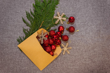 New Year's, Christmas red decorations in an envelope and coniferous branches on a gray background
