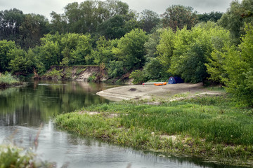 Fototapeta na wymiar Tourist tent and boat on the river bank