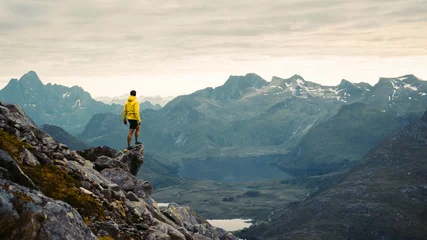Gordijnen Man standing on mountain top and looking at landscape © Pavel Kašák