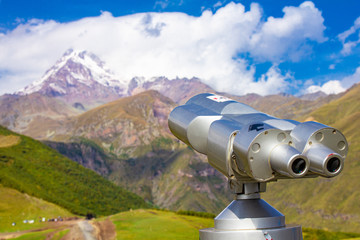 Binoscope directed towards the snowy mountain tops of Kazbeg from the view point Gergeti Trinity Church Tsminda Sameba Holy Church near the village of Gergeti in Georgia