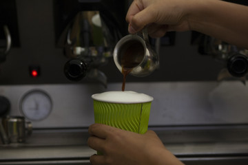 barista making hot coffee with milk