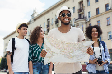 Happy hipsters using navigation map to explore the city