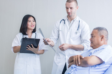 Fototapeta premium Healthcare and medical people concept, doctor looking on X-ray film of old patient and checking problem of spine bone and explaining
