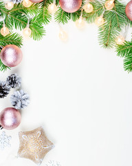 Christmas background with fir tree branches, Christmas lights, pink and beige decorations, silver ornaments