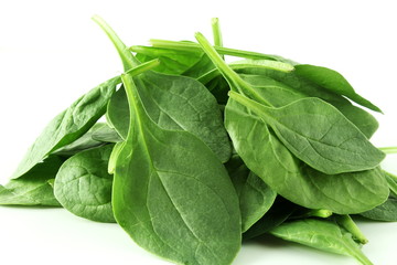 green spinach leaves isolated closeup on white background 