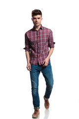 shocked young casual man wearing plaid shirt stepping