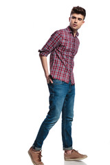 relaxed casual man wearing jeans walks and looks to side