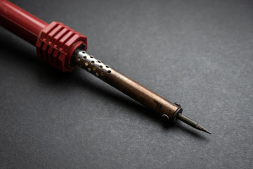Soldering iron on dark background.