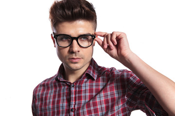 portrait of handsome nerd fixing sunglasses and looking to side
