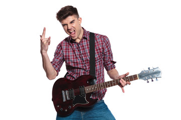 young star making rock on sign while performing on guitar