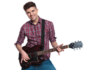 happy young man playing his electric guitar and smiling