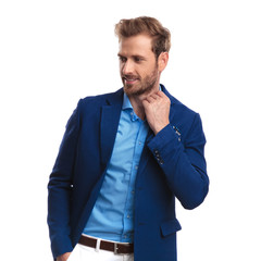 smiling casual man fixing his collar looks away