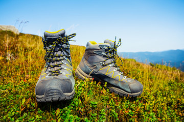 closeup pair of touristic boots on the mountain slope