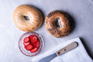 Breakfast of Coffee, Bagels, Cream Cheese, Blackberries and Strawberries on a Marble Surface.