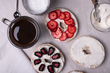 Breakfast of Coffee, Bagels, Cream Cheese, Blackberries and Strawberries on a Marble Surface.