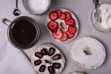Breakfast of Coffee, Bagels, Cream Cheese, Blackberries and Strawberries on a Marble Surface.
