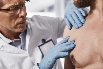 Close up of adult specialist looking chest area and trying to ascertain absence of pathologies