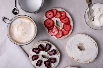 Breakfast of Coffee, Bagels, Cream Cheese, Blackberries and Strawberries on a Marble Surface.