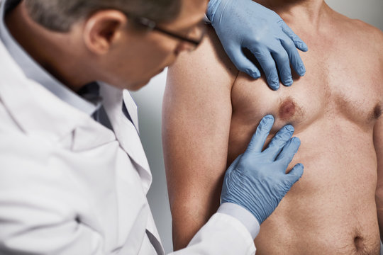 Close up of doctor conducting external examination and palpation of patient chest for finding various pathologies