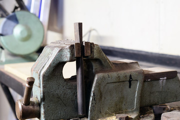 Metal workshop equipments. Vise on foreground, bench grinder on background. Copy space.