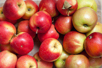 Several ripe red apples lay in layer