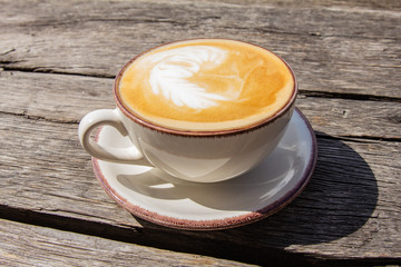 Good morning with aromatic coffee cappuccino in white cup with on table wooden in cafe