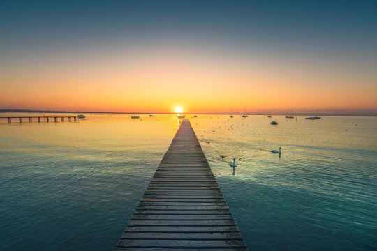Garda lake, swans and jetty, sunset view from Pacengo Lazise. Italy © stevanzz