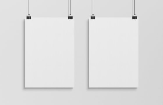 Two blank white poster hanging up with clips mockup