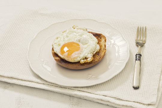 Toasted Bagel with Fried Egg on White Plate