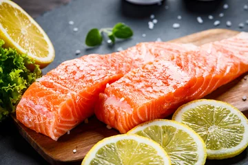 Crédence de cuisine en verre imprimé Poisson Poisson saumon cru frais servi sur pierre noire sur table en bois